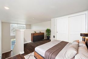 Seattle apartment for rent - A bedroom with a large bed and a wooden dresser.
