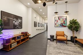 Seattle apartment for rent - A hallway with a chair, a plant, and a painting on the wall.