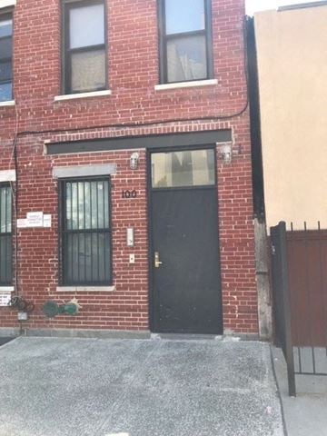 Brooklyn apartment for rent - A red brick building with a black door and windows.