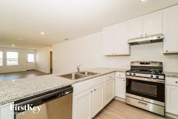 San Antonio house for rent - a kitchen with white cabinets and granite counter tops and stainless steel appliances