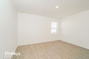 San Antonio house for rent - a bedroom with white walls and wood floors and a window