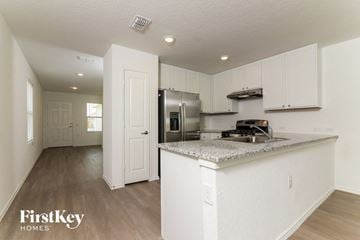San Antonio house for rent - A kitchen with a refrigerator, stove, and cabinets.
