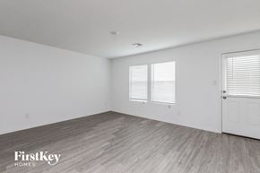 Saint Hedwig house for rent - a bedroom with white walls and wood floors and a white door