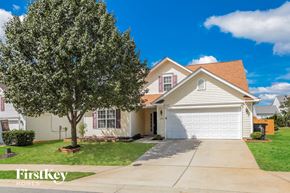 Winston Salem house for rent - a white house with a white garage door and a tree