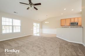 Winston Salem house for rent - an empty living room and kitchen with a ceiling fan
