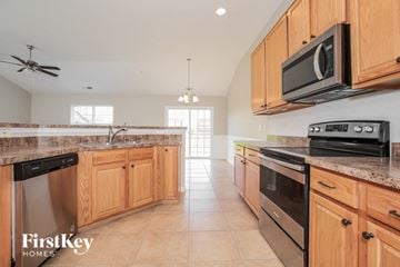 Winston Salem house for rent - a kitchen with wooden cabinets and stainless steel appliances