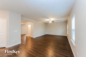Cartersville house for rent - an empty living room with wood flooring and white walls