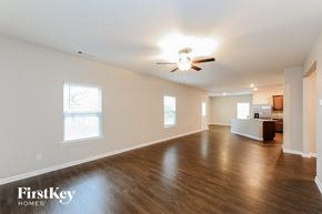 Cartersville house for rent - an empty living room with wood floors and a ceiling fan