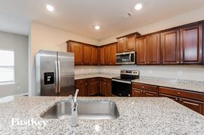 Cartersville house for rent - a kitchen with granite counter tops and wooden cabinets