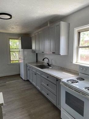 Clairton apartment for rent - A kitchen with white cabinets and a white stove top oven.