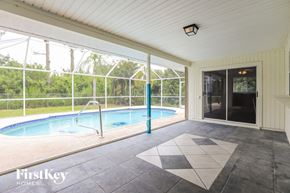Port Charlotte house for rent - a swimming pool in a house with a glass door and a patio