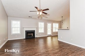 Dallas house for rent - an empty living room with a ceiling fan and a fireplace