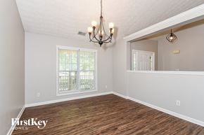 Dallas house for rent - the spacious living room with a large window and a chandelier