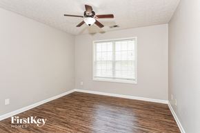 Dallas house for rent - a bedroom with a ceiling fan and wood floors
