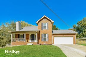 Clarksville house for rent - A brick house with a garage door and a chimney.