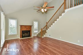 Clarksville house for rent - A spacious living room with a fireplace and a staircase.