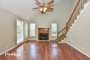 Clarksville house for rent - A spacious room with a fireplace and wooden floors.