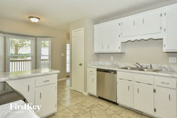 Clarksville house for rent - A kitchen with white cabinets and a tiled floor.