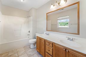 Jacksonville house for rent - A bathroom with a toilet, sink, and mirror.