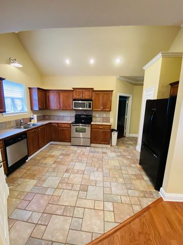 Youngsville house for rent - a kitchen with wooden cabinets and a tiled floor