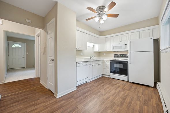 Lombard apartment for rent - an empty kitchen with white cabinets and a ceiling fan
