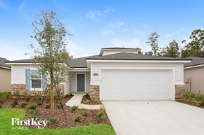 Jacksonville house for rent - a white house with a white garage door and a tree