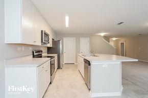 Jacksonville house for rent - a large kitchen with white cabinets and stainless steel appliances