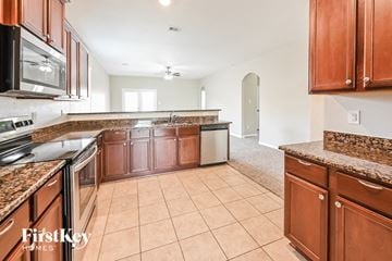 Hockley house for rent - A kitchen with brown cabinets and a tile floor.