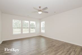Greenville house for rent - A spacious room with a ceiling fan and wooden flooring.