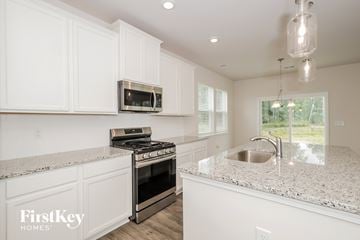 Greenville house for rent - A kitchen with white cabinets and a granite countertop.