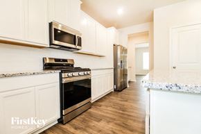 Greenville house for rent - a kitchen with white cabinets and stainless steel appliances