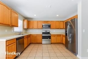 Davenport house for rent - an empty kitchen with wooden cabinets and stainless steel appliances