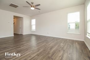 Simpsonville house for rent - an empty living room with wood flooring and a ceiling fan