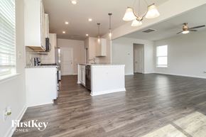 Simpsonville house for rent - the kitchen and living room of a new home with white walls and wood flooring