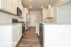 Simpsonville house for rent - a kitchen with white cabinets and a counter top