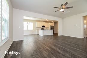 Simpsonville house for rent - A spacious living room with a kitchen in the background and a wood floor.
