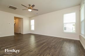 Simpsonville house for rent - A spacious room with wooden flooring and a ceiling fan.