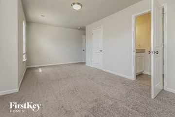 Simpsonville house for rent - a spacious living room with carpet and a door to a bathroom
