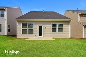 Simpsonville house for rent - the front of a house with a grassy yard and two neighboring houses