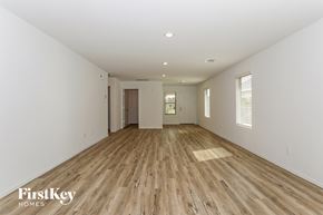 Magnolia house for rent - a spacious living room with hardwood floors and white walls