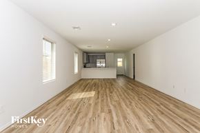 Magnolia house for rent - the living room and kitchen of a new home with wood floors and white walls