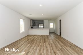 Magnolia house for rent - a renovated living room and kitchen with hardwood floors and white walls