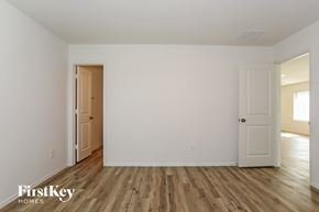 Magnolia house for rent - the living room of a house with white walls and wooden floors