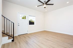 San Diego house for rent - an empty living room with white walls and a ceiling fan