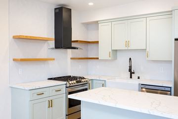 San Diego house for rent - a kitchen with white marble counter tops and white cabinets