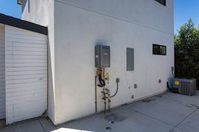 San Diego house for rent - the side of a building with a gas meter and a garage door