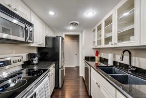 Grand Prairie house for rent - A kitchen with black appliances and white cabinets.