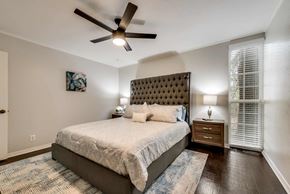 Grand Prairie house for rent - A bedroom with a large bed and a ceiling fan.