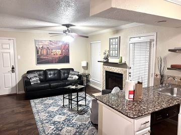 Irving house for rent - a living room with a kitchen and a couch and a fireplace