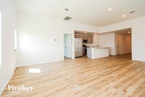 La Marque house for rent - a renovated living room and kitchen with wood floors and white walls